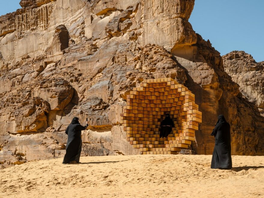 Skulptur in der Wüste, Frauen in Burkas davor